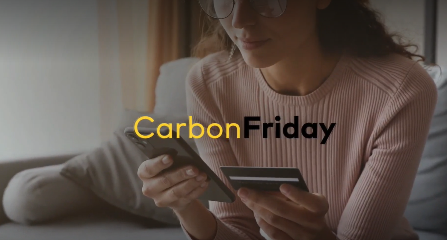 Mulher segurando o cartão black verificando os descontos da Carbon Friday